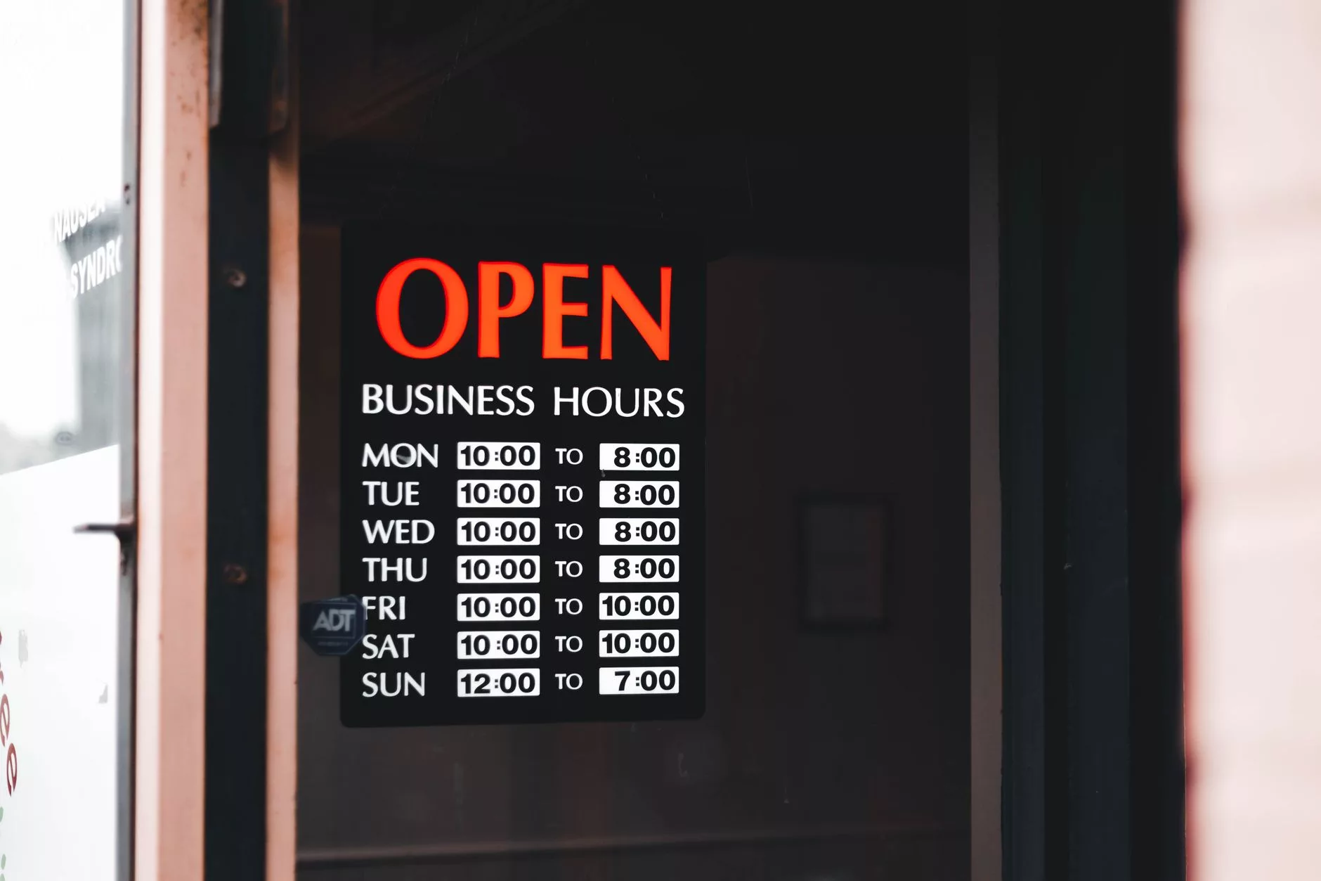 close-up of a mobile phone screen displaying business operating hours and active status