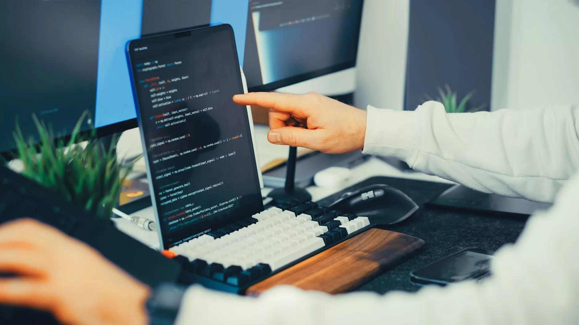Extending Functionality with Plugins and Themes programmer looking closely at code blocks on a dual monitor workstation