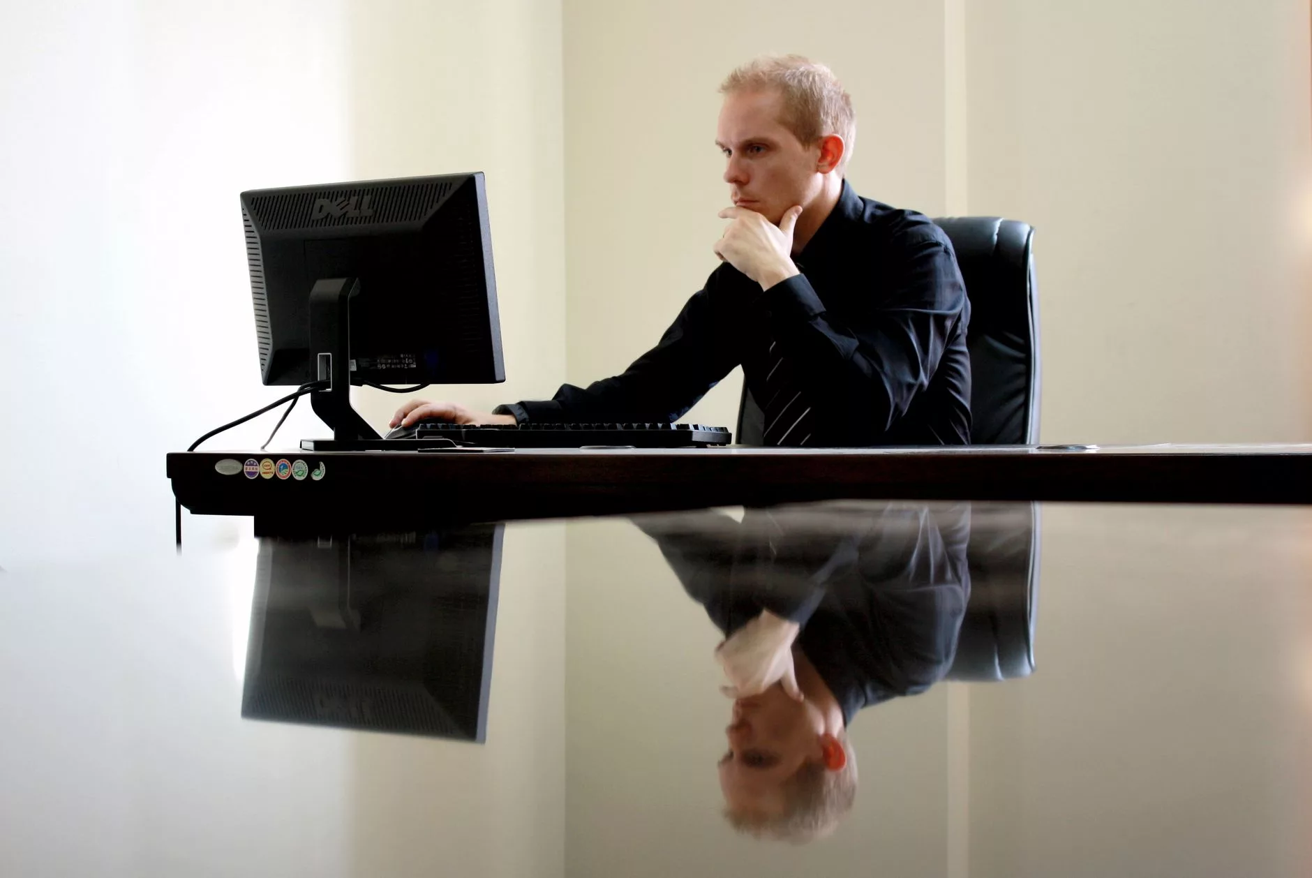 An executive looking thoughtfully at data displayed on a computer screen.
