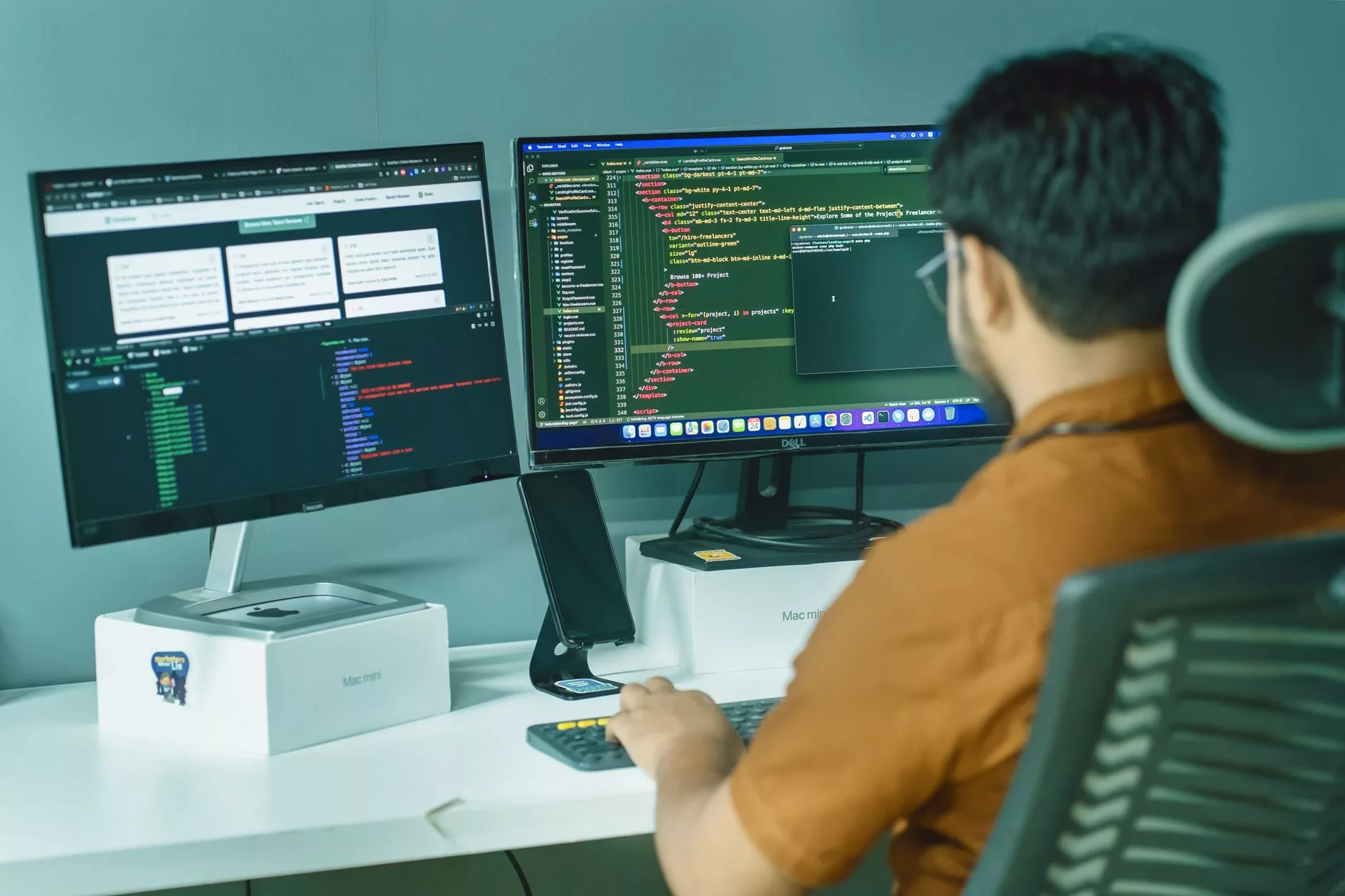 A software developer writing custom WordPress theme code on dual computer monitors in a bright office
