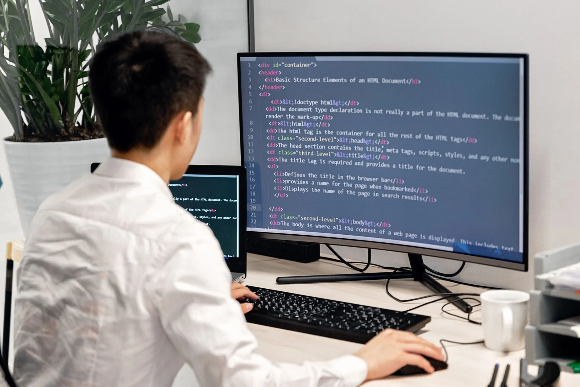 software developer writing modern web code on two computer monitors
