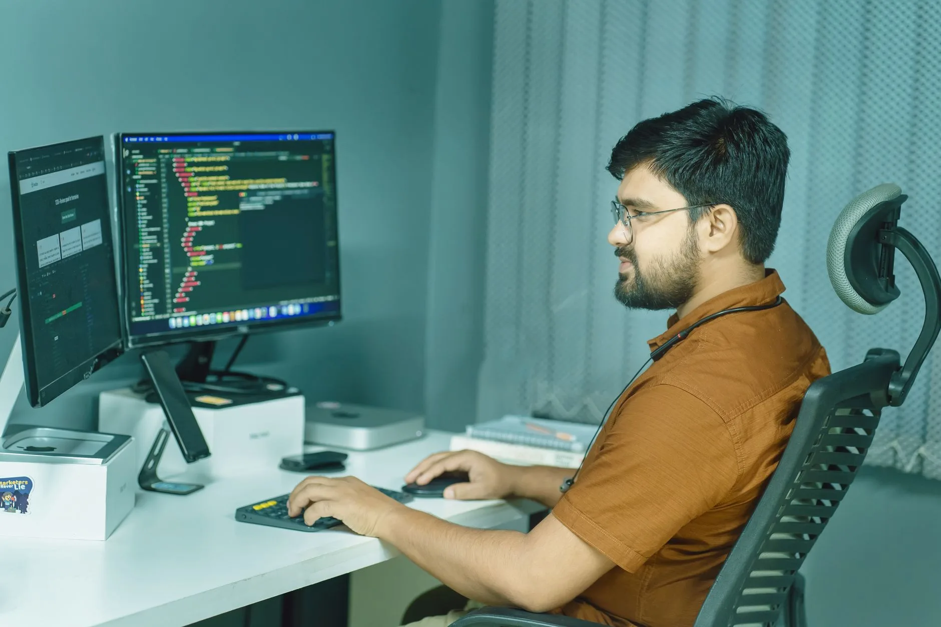 software engineer analyzing database code on dual computer monitors in modern office